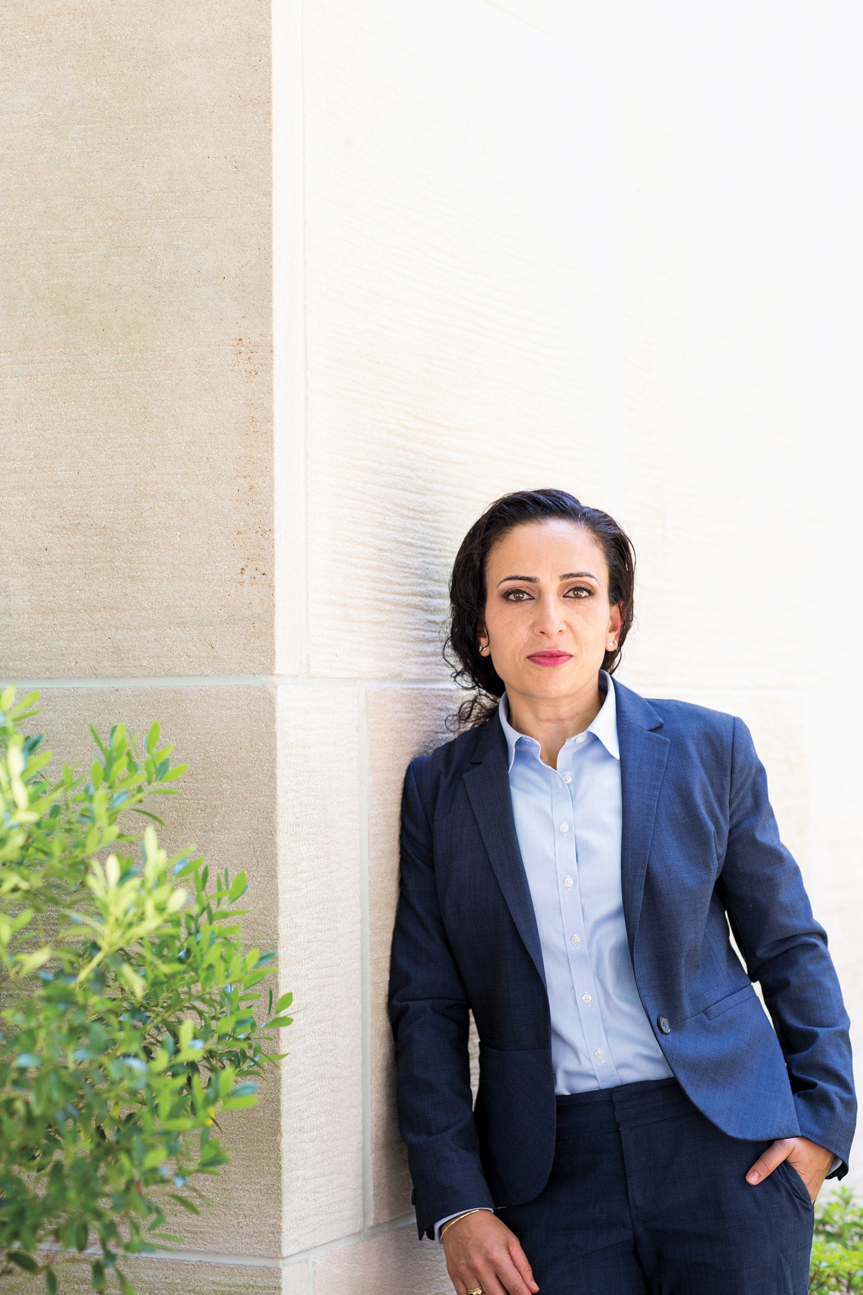 Naz K. Modirzadeh leaning against a wall